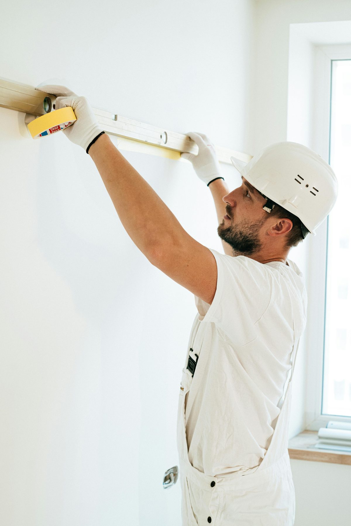 Vakkundige stukadoor controleert wand met waterpas